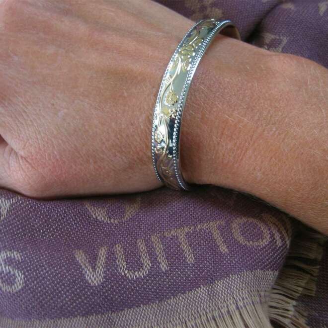 Magnetic bracelet with intricate design in a silver and gold finish